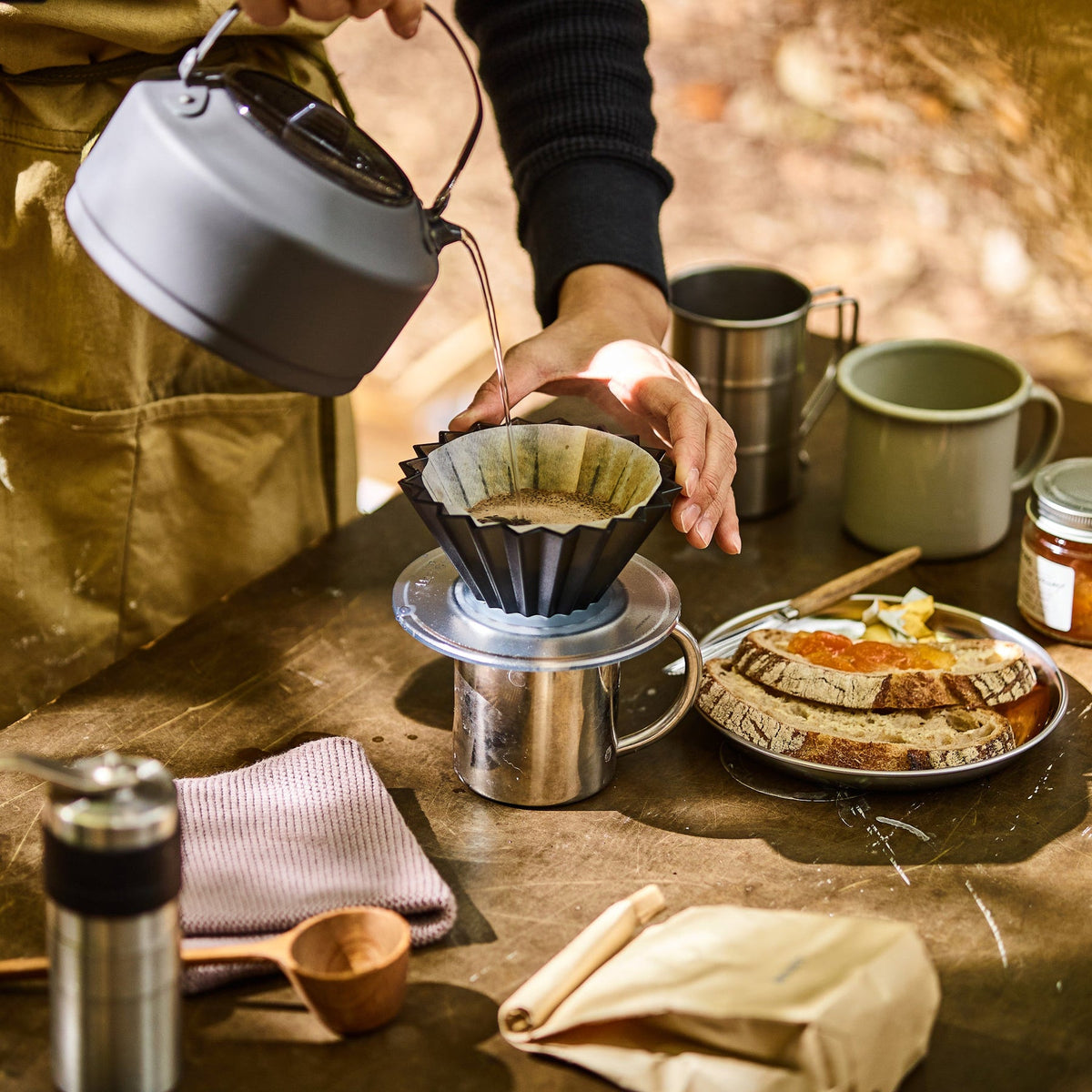 Black Comandante Origami Air S plastic coffee grinder with sleek design and manual burr grinding mechanism.