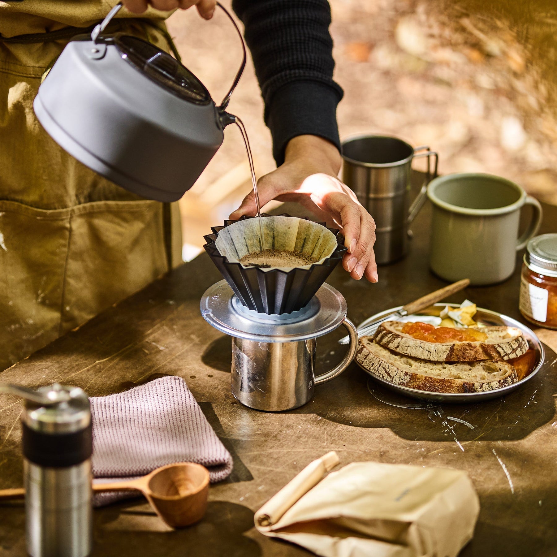 Black Comandante Origami Air S plastic coffee grinder with sleek design and manual burr grinding mechanism.
