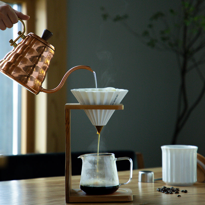 Orange Comandante coffee grinder with Origami Dripper S for fresh brewing, featuring a compact and stylish design.