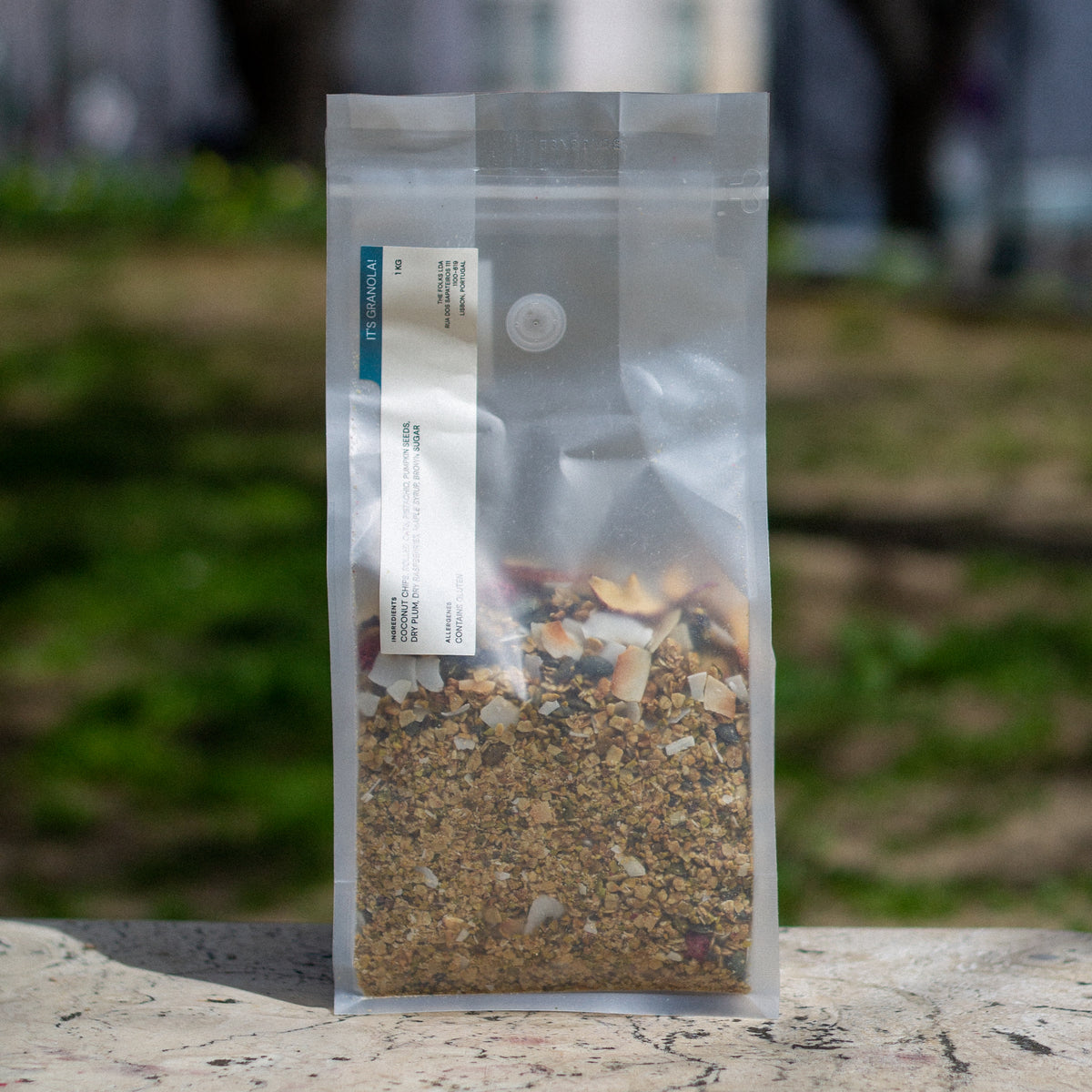 A 1kg bag of The Folks granola with a close-up view of the crunchy, toasted granola clusters in a natural setting.